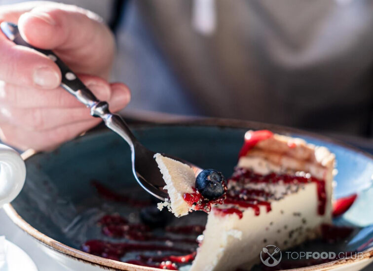 2021-08-18-3hg2bm-cheesecake-with-fresh-berry-on-a-spoon-next-to-a-c-me8y7tu