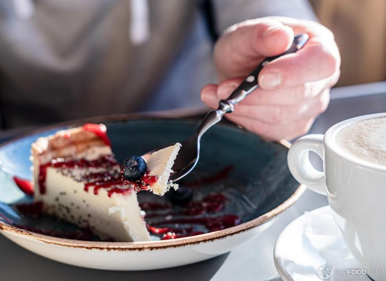 2021-08-18-7ry1ti-cheesecake-with-fresh-berry-on-a-spoon-next-to-a-c-me8y7tu