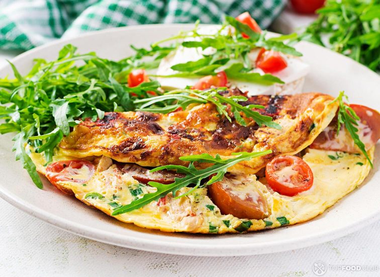 2021-08-23-vg9xnj-omelette-with-tomatoes-cheese-and-green-herbs-on-p-ttw5hfz