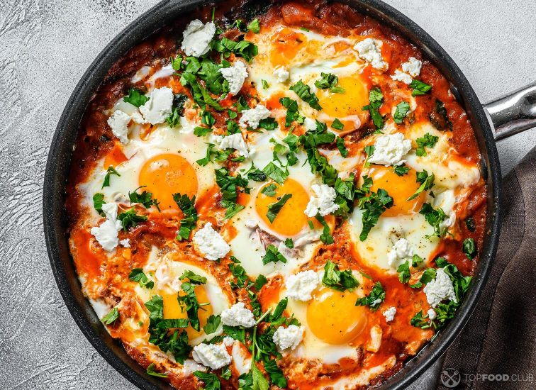 2021-09-13-6jkz5o-homemade-shakshuka-fried-eggs-onion-bell-pepper-tomatoes-and-parsley-in-a-pan-gray-background-top-view