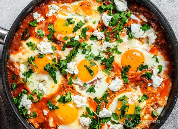 2021-09-15-bae7m3-homemade-shakshuka-fried-eggs-onion-bell-pepper-tomatoes-and-parsley-in-a-pan-gray-background-top-view