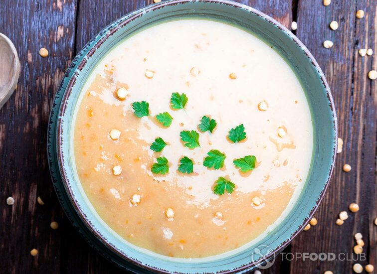 2021-09-20-9egrwz-pea-soup-in-green-bowl-on-brown-wooden-background-pq2wv3l