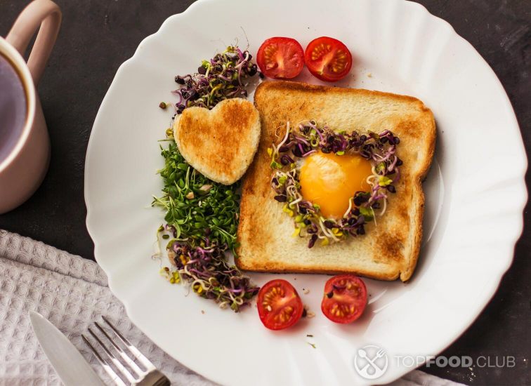 2021-10-26-6b250t-egg-hole-bread-heart-shape-microgreens-healthy-food-breakfast-tea-black-background