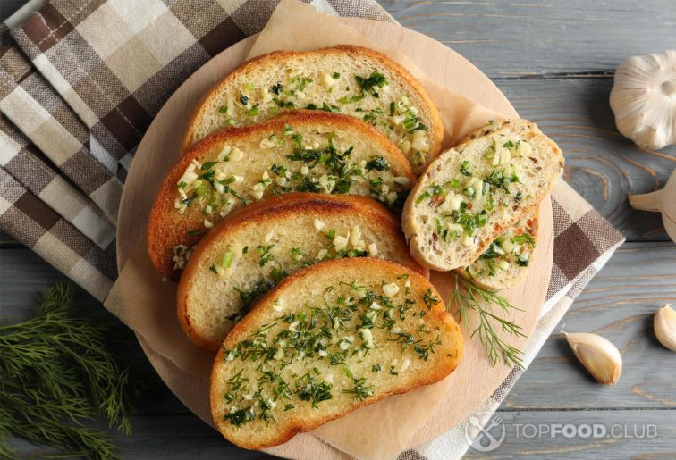 2021-11-04-ts4kje-plate-with-toasted-garlic-bread-and-dill-on-wooden-2021-09-02-21-36-28-utc