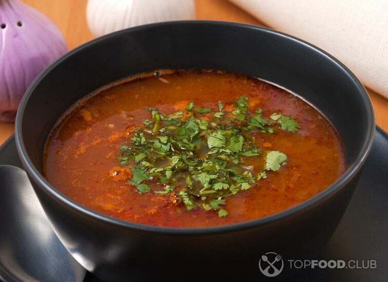 2021-12-30-kf4lve-kharcho-soup-with-beef-in-a-dark-bowl-decorated-with-greens