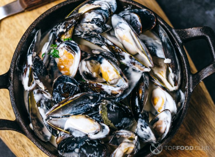 2023-05-24-5d8pl3-mussels-in-a-creamy-garlic-sauce-in-a-black-metal-2022-05-01-23-03-12-utc