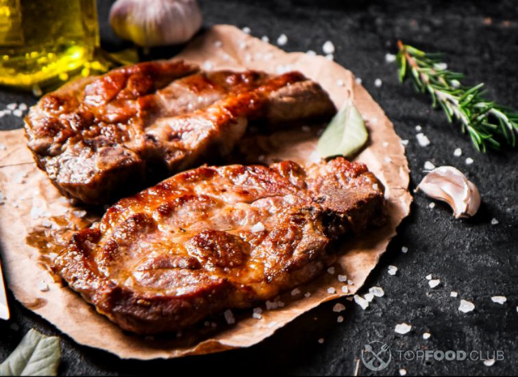 2023-08-03-jsz0mk-grilled-pork-steak-on-paper-with-rosemary-2022-02-24-22-19-26-utc