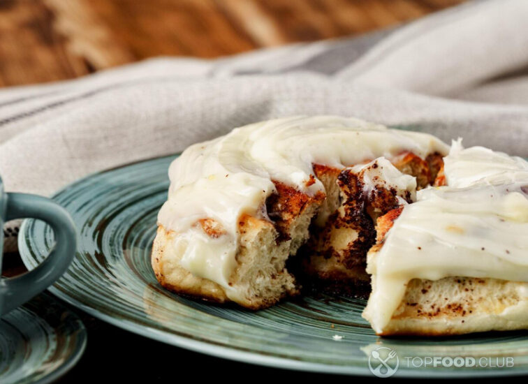 2021-08-17-dika1v-glazed-cinnabon-bun-in-green-plate-on-wooden-table-lve4bxt