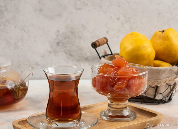 2021-09-09-vc031o-glass-of-tea-jam-and-quince-fruits-on-wooden-plate-w6u5qdu