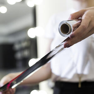 Отрывает фольгу