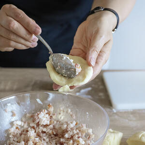 Кладет начинку в тесто