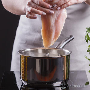 Кладёт куриное филе в кастрюлю