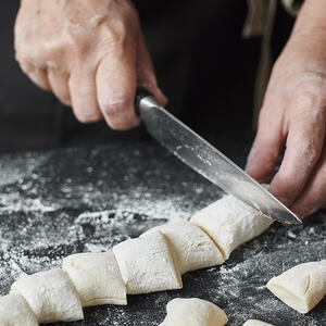 Нарезает тесто