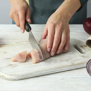 Нарезает куриное филе