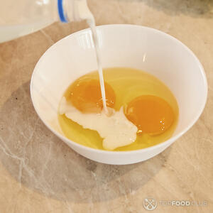 Добавляет молоко в яйца