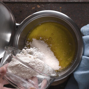 Добавляет муку в масло