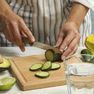 Нарезает огурец