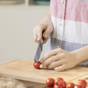 нарезает помидоры черри