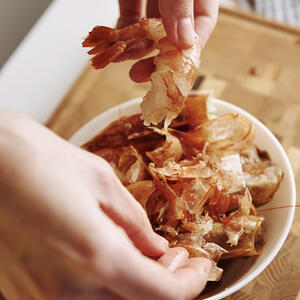 чистит креветки