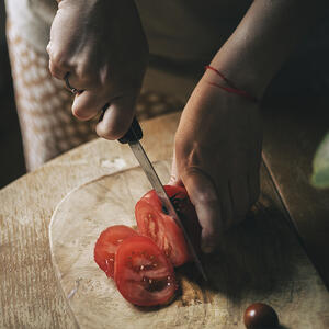 нарезает помидоры