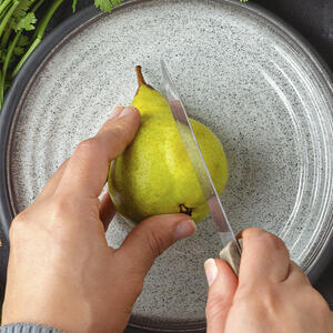 нарезает грушу