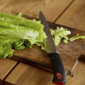 нарезает листья салата