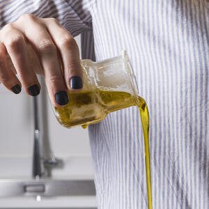 наливает оливковое масло
