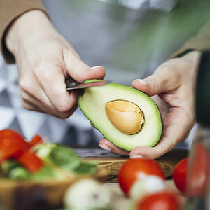 чистит авокадо