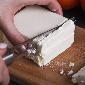 нарезает сыр фета
