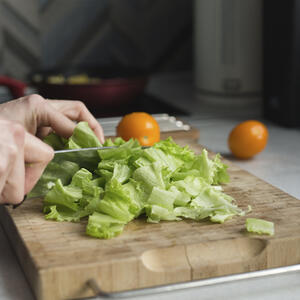 нарезает листья салата