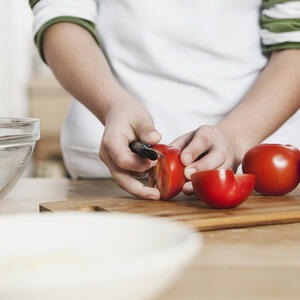 нарезает помидоры