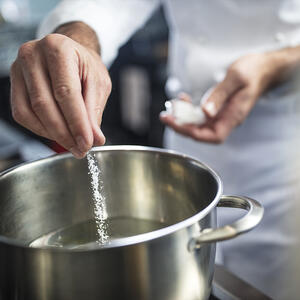 солит воду в кастрюле