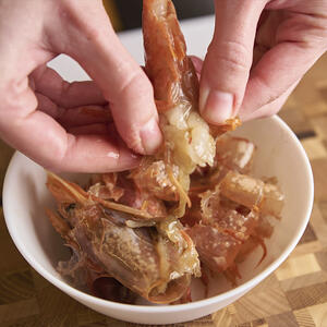 чистит креветки