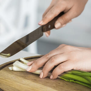 нарезает зеленый лук