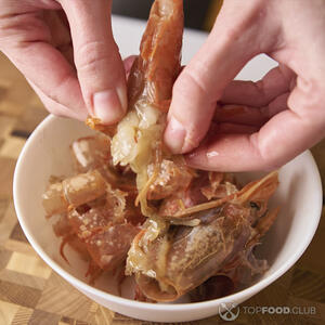 чистит креветки