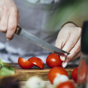 нарезает помидоры