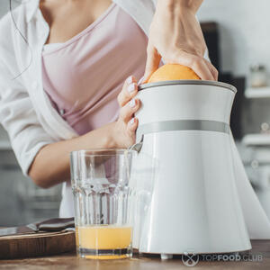 добывает сок из апельсина