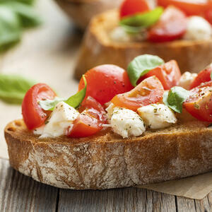 На подготовленные ломтики багета выложите помидорную смесь, разделив ее поровну. Брускетты подавайте сразу, сбрызнув капелькой оливкового масла первого отжима.