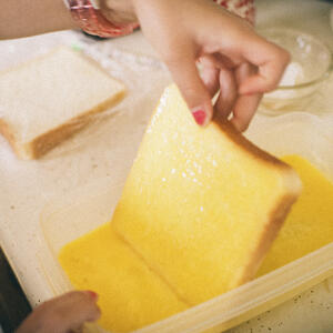 В яичную смесь обмакните ломтики батона, дайте им хорошо пропитаться с обеих сторон