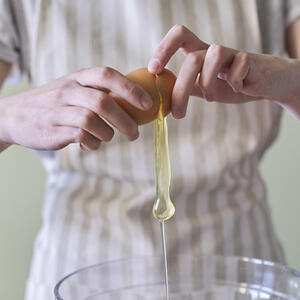 разбивает яйцо