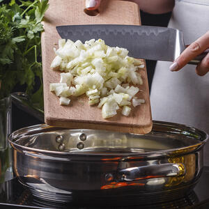 добавляет в сковороду лук