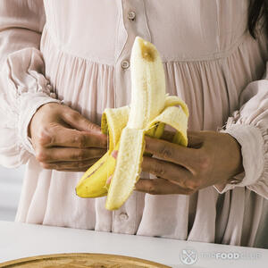 чистит бананы