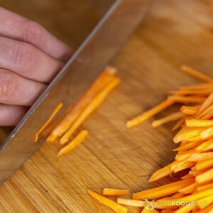 нарезает морковь соломкой