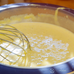 Смешать желток, сметану, молоко и специи