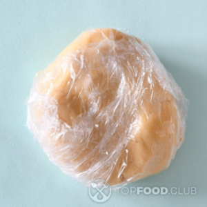 Обернуть тесто пищевой пленкой