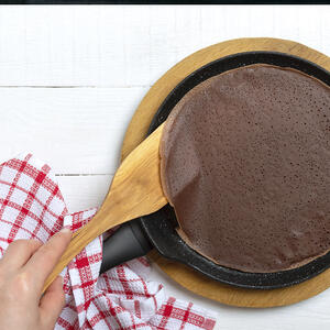 Поворачивая сковороду, распределите тесто тонким слоем и обжаривайте 30-45 секунд первую сторону блина, пока края не станут золотистыми.