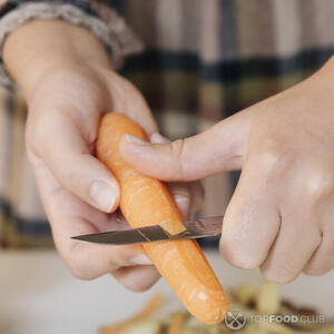 Чистит морковь