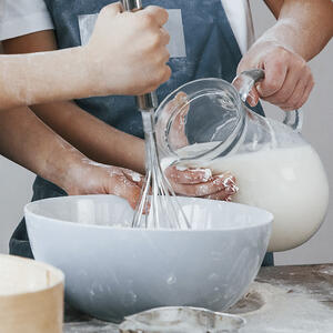 Тонкой струйкой вливайте молоко в тесто