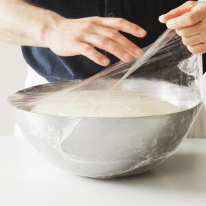 Тесто перелейте в миску, накройте пищевой пленкой и пока отставьте на 2 часа.