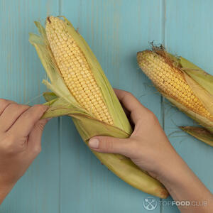 чистит кукурузу